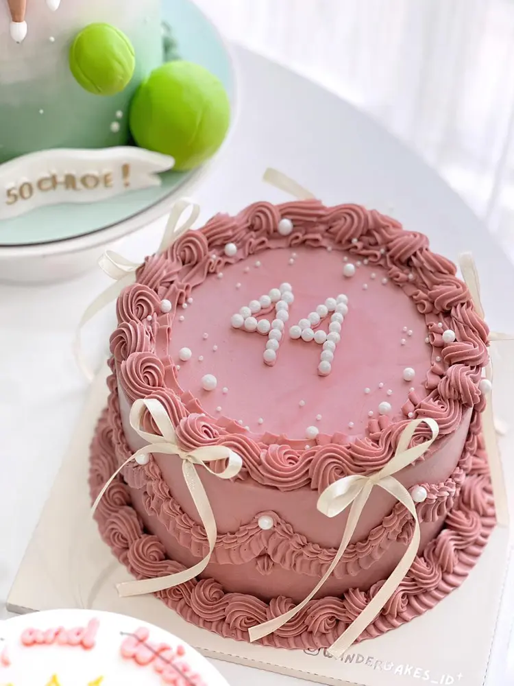 Cake vintage pink dengan angka 44 dari mutiara dan pita krem