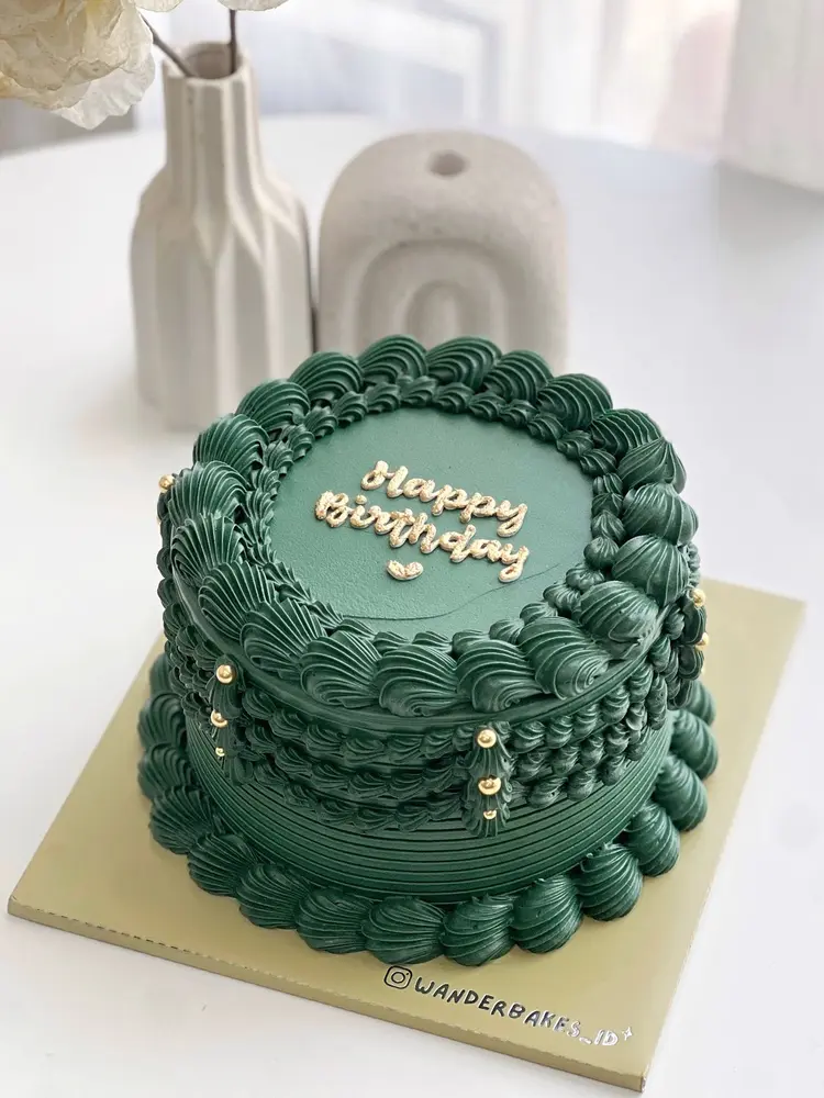 Cake vintage hijau tua dengan piping berlapis dan tulisan Happy Birthday emas