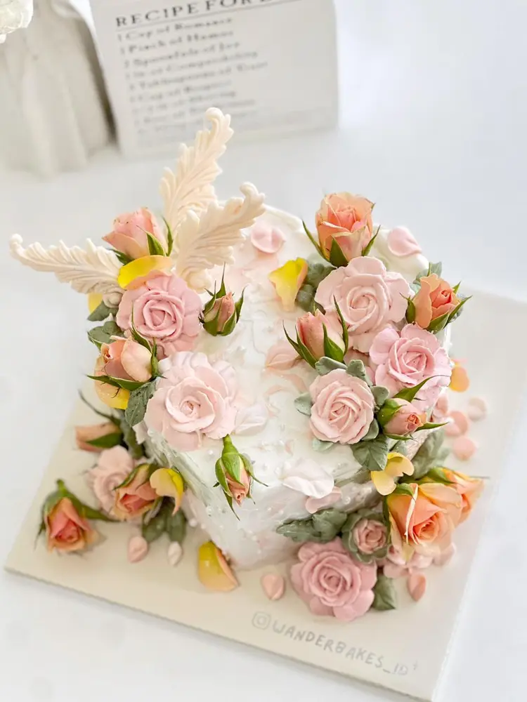 Cake crowned with peach and pink buttercream roses